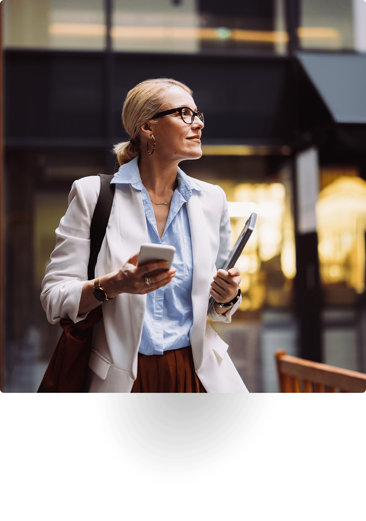 Executive woman holding phone and laptop