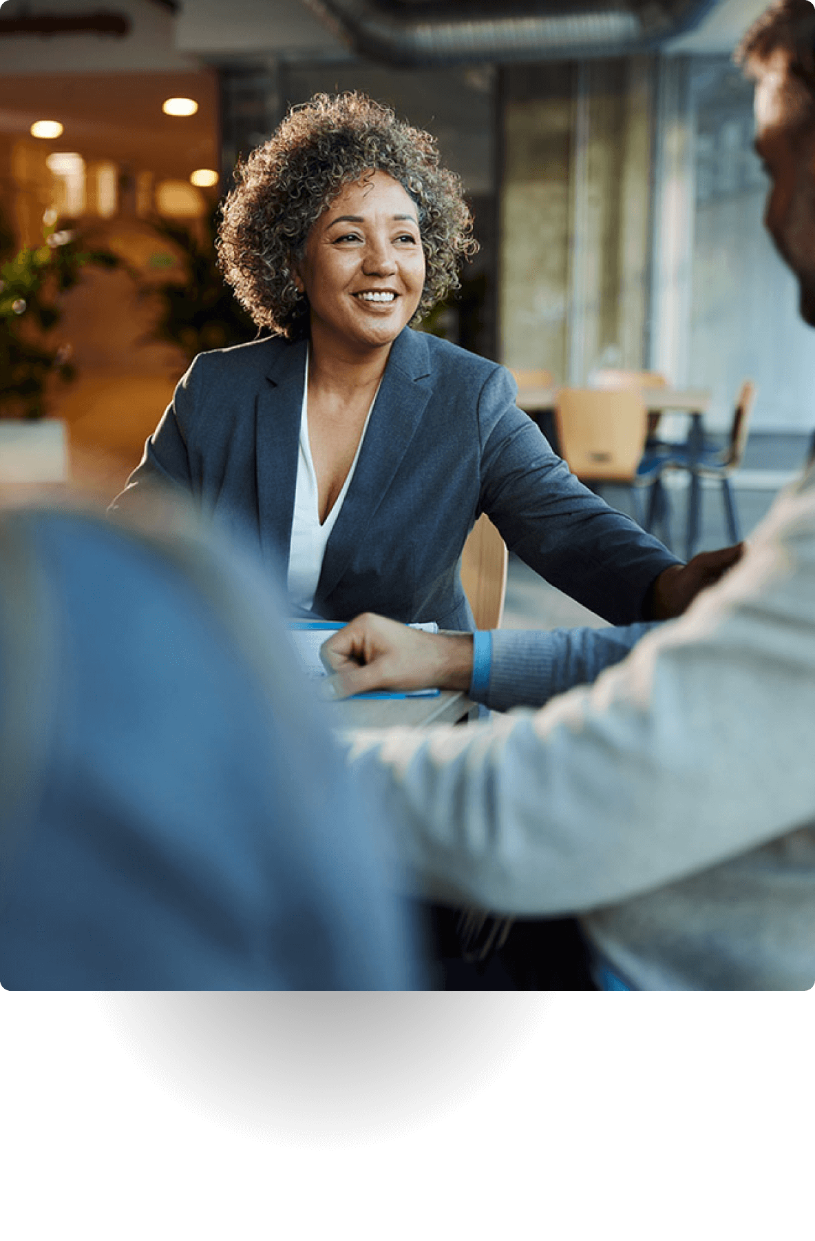 Smiling businesswoman meeting with colleagues in office setting.
