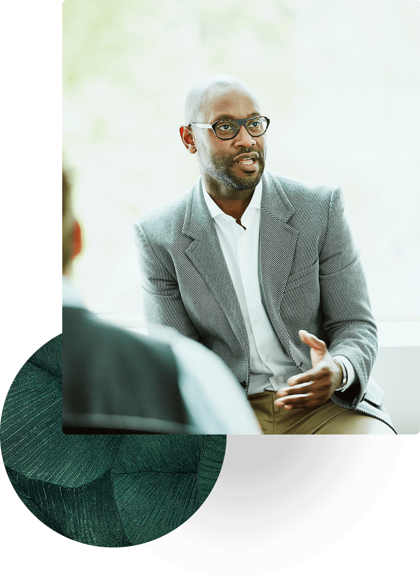 Man in glasses and blazer speaking during a business meeting