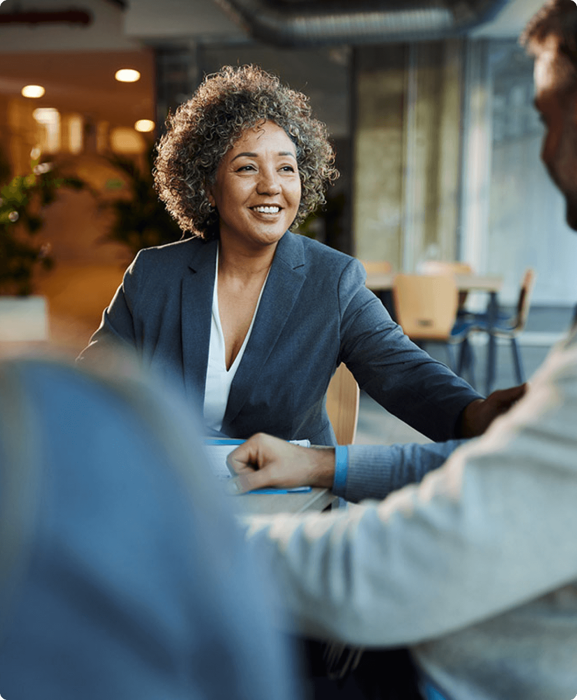 Smiling businesswoman meeting with colleagues in office setting.