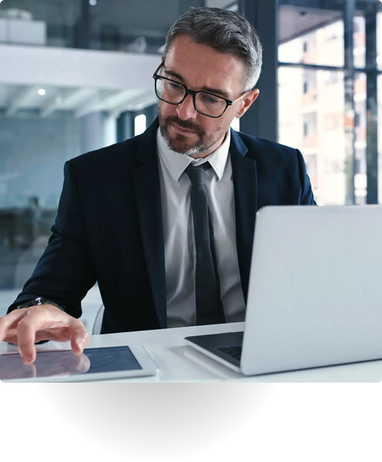 Businessman in suit working at a desk in office setting.