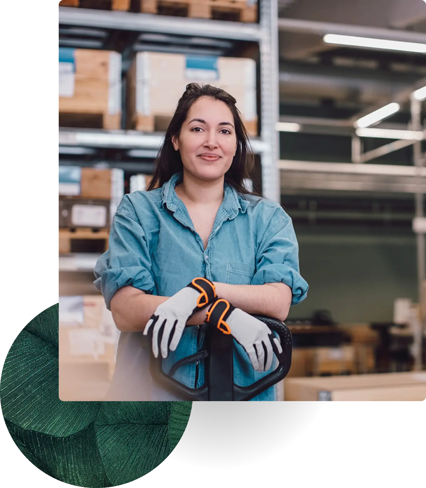 Woman in a warehouse wearing gloves, leaning on equipment.