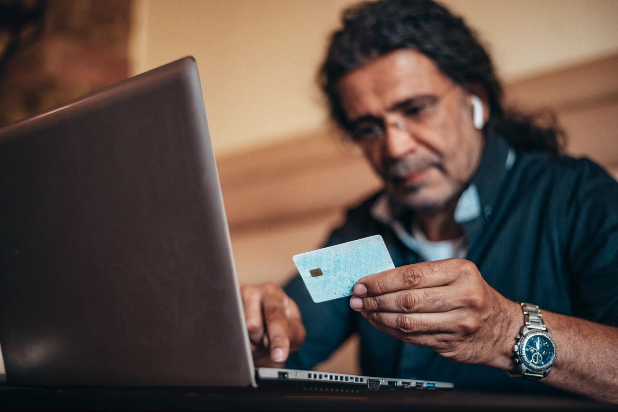 elder man at laptop falling for bank scam