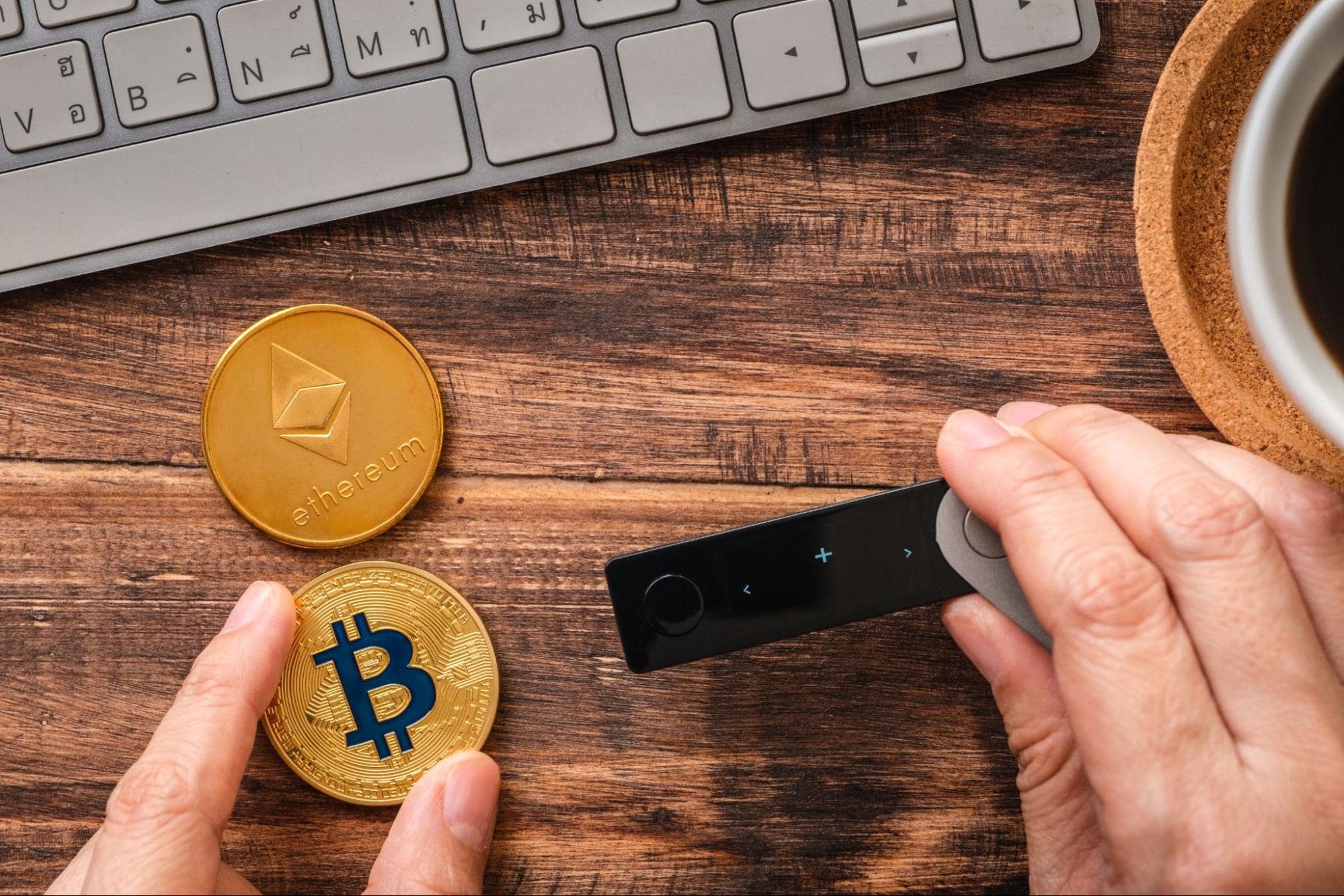 coins representing cryptocurrency in front of a laptop in a man’s hands avoiding crypto scams