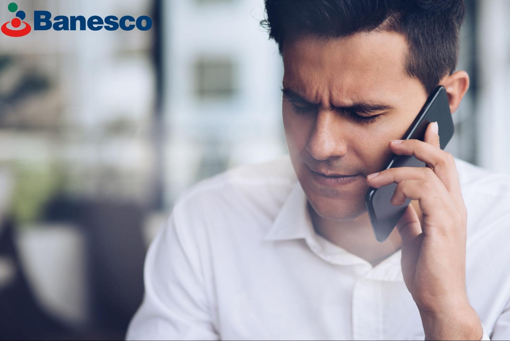 A businessman looks concerned as he realizes he is on the receiving end of an AI scam call. The Banesco USA logo is visible.